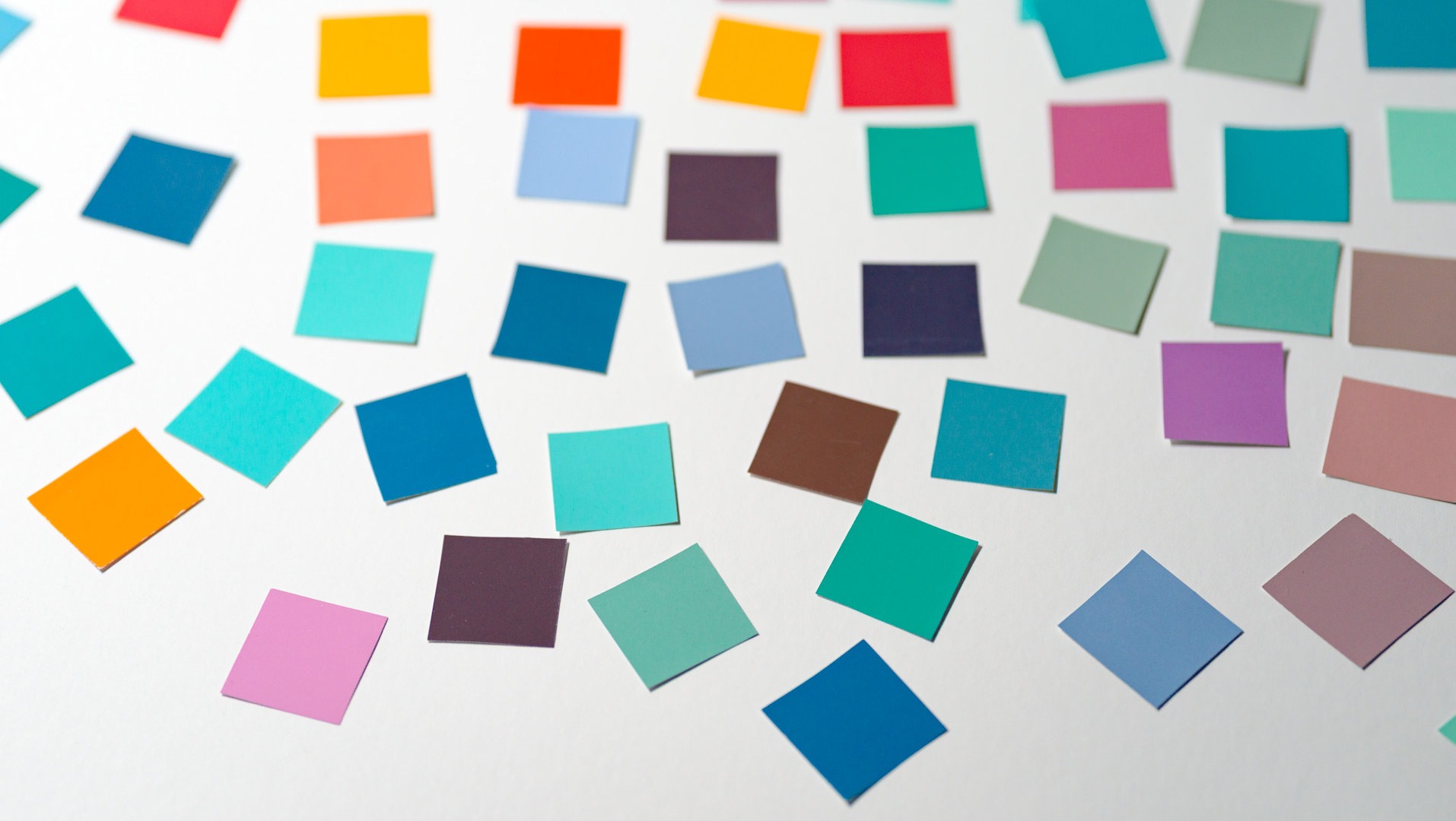 Des post-its multicolores sont étalés sur une surface blanche.