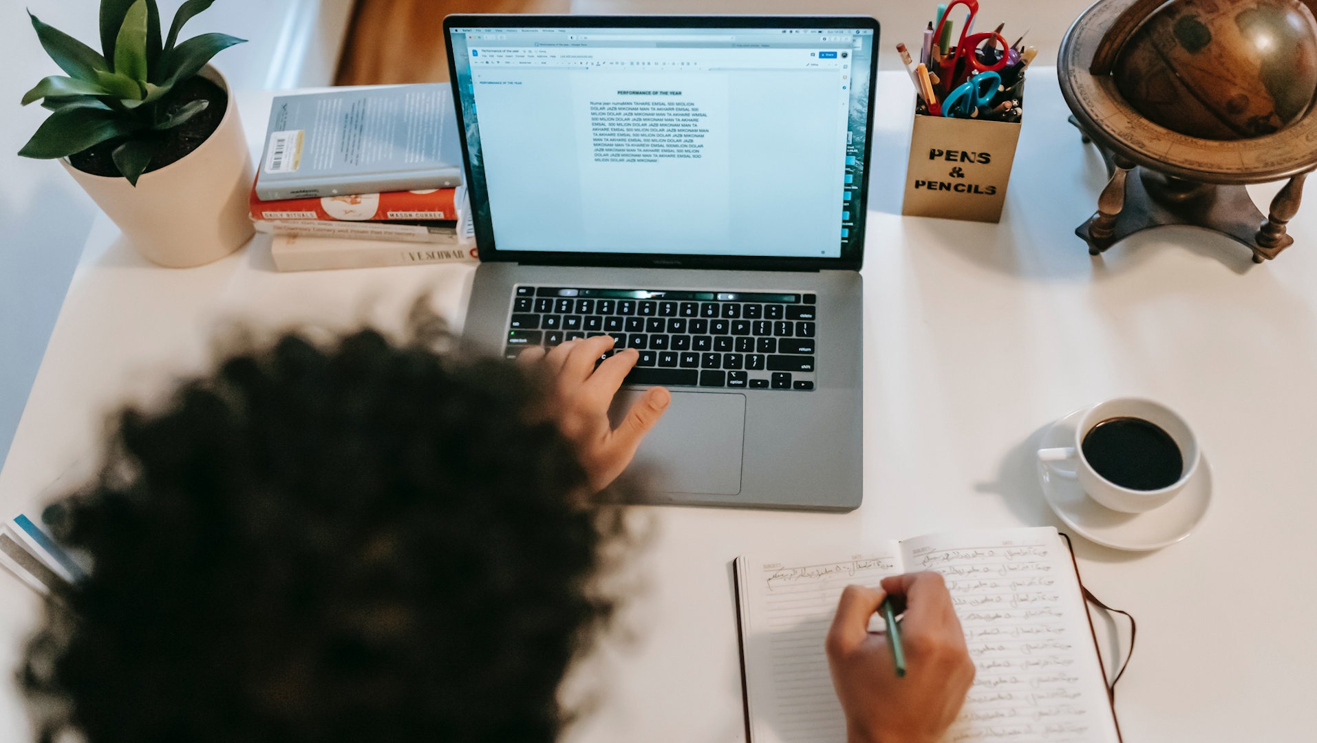 Une personne recopie un texte manuscrit sur un ordinateur.