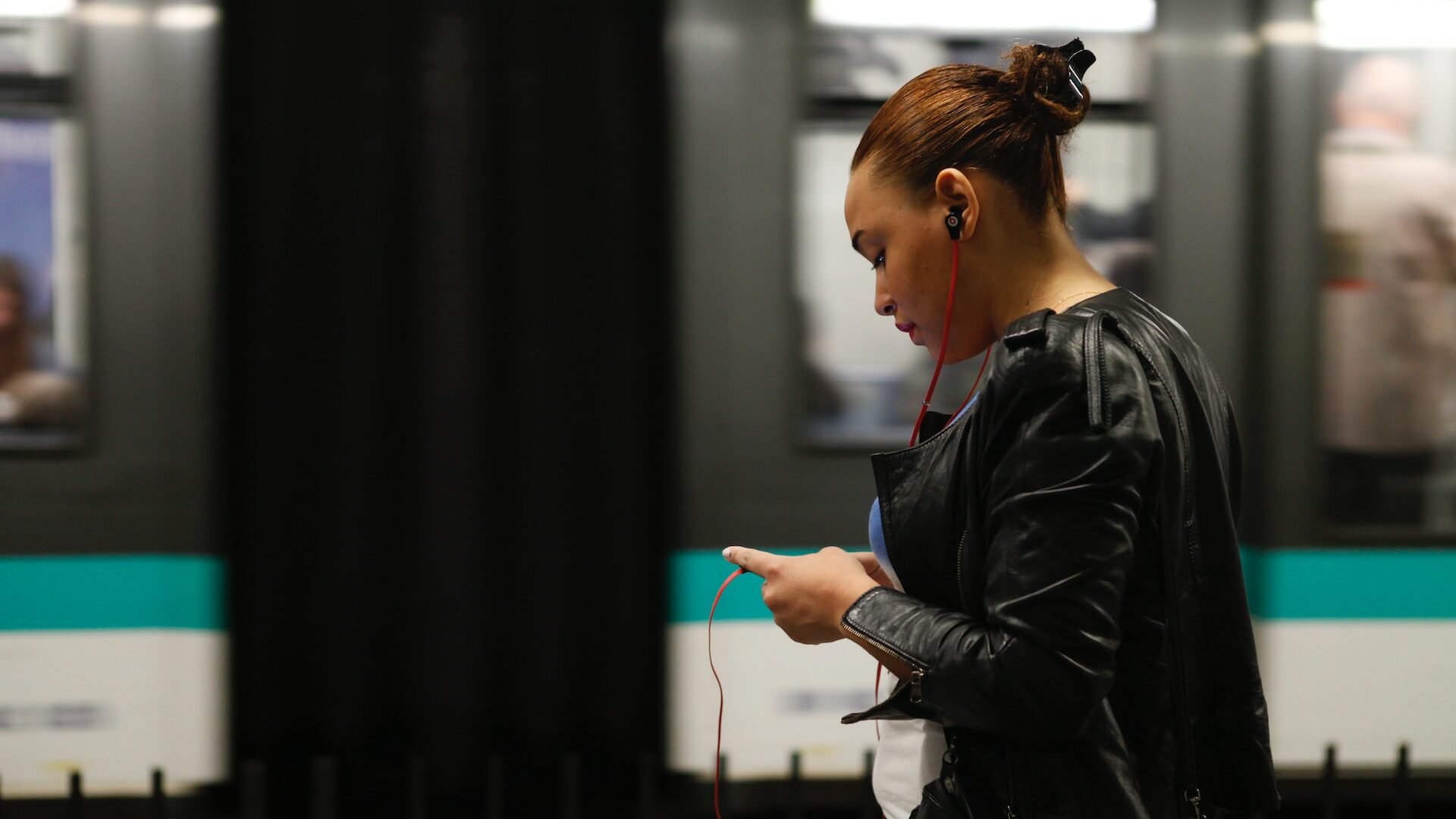 Femme qui regarde son smartphone dans le métro parisien.